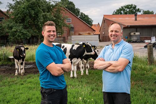 Landwirt mit seinem Sohn auf einer Wiese